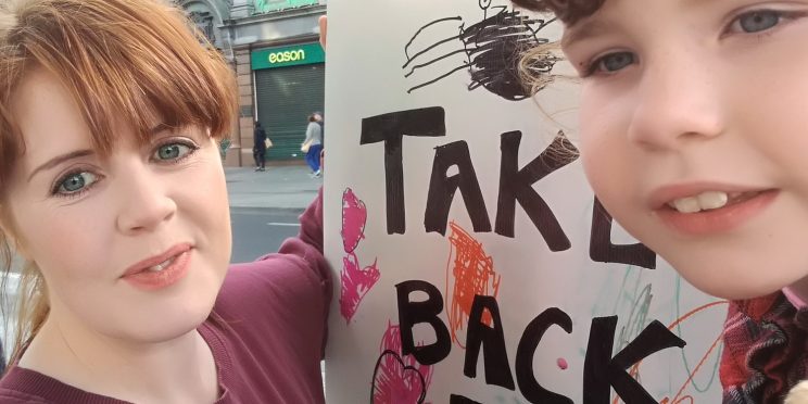 Neasa with "Take back the city" poster